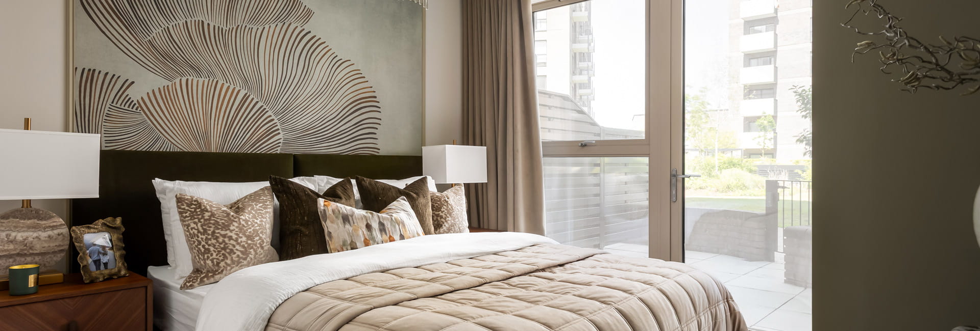Double bed with contemporary design, bedside tables and wall hanging.