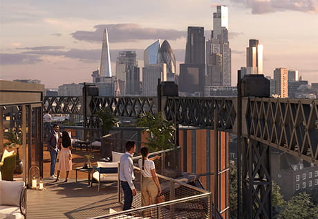 People on a rooftop terrace bar overlooking the London skyline at sunset, with the Shard and Gherkin visible.