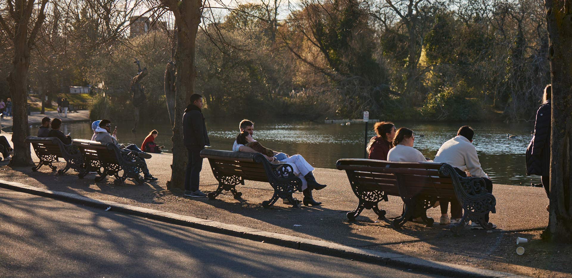 An image of people sat on benches in the park