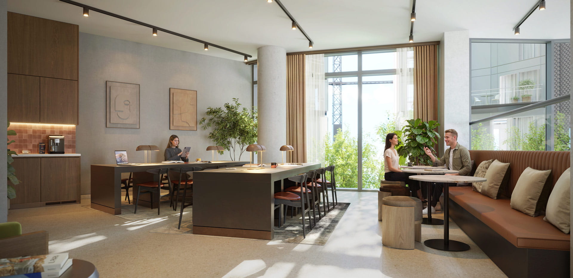 Modern social workspace with shared desk, booth seating, kitchenette and floor-to-ceiling windows.