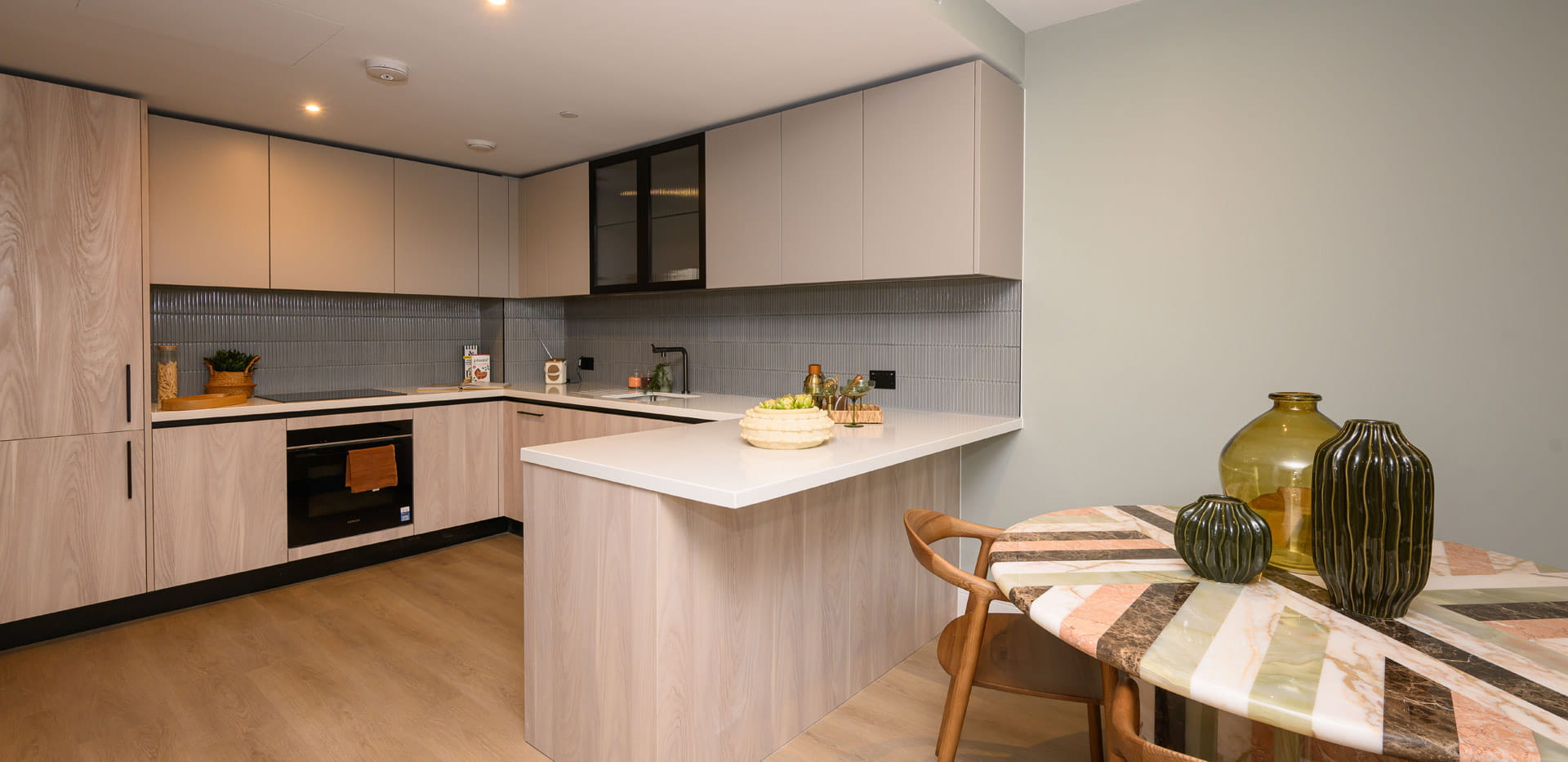 Kitchen with island with neutral tones, circular dining table.