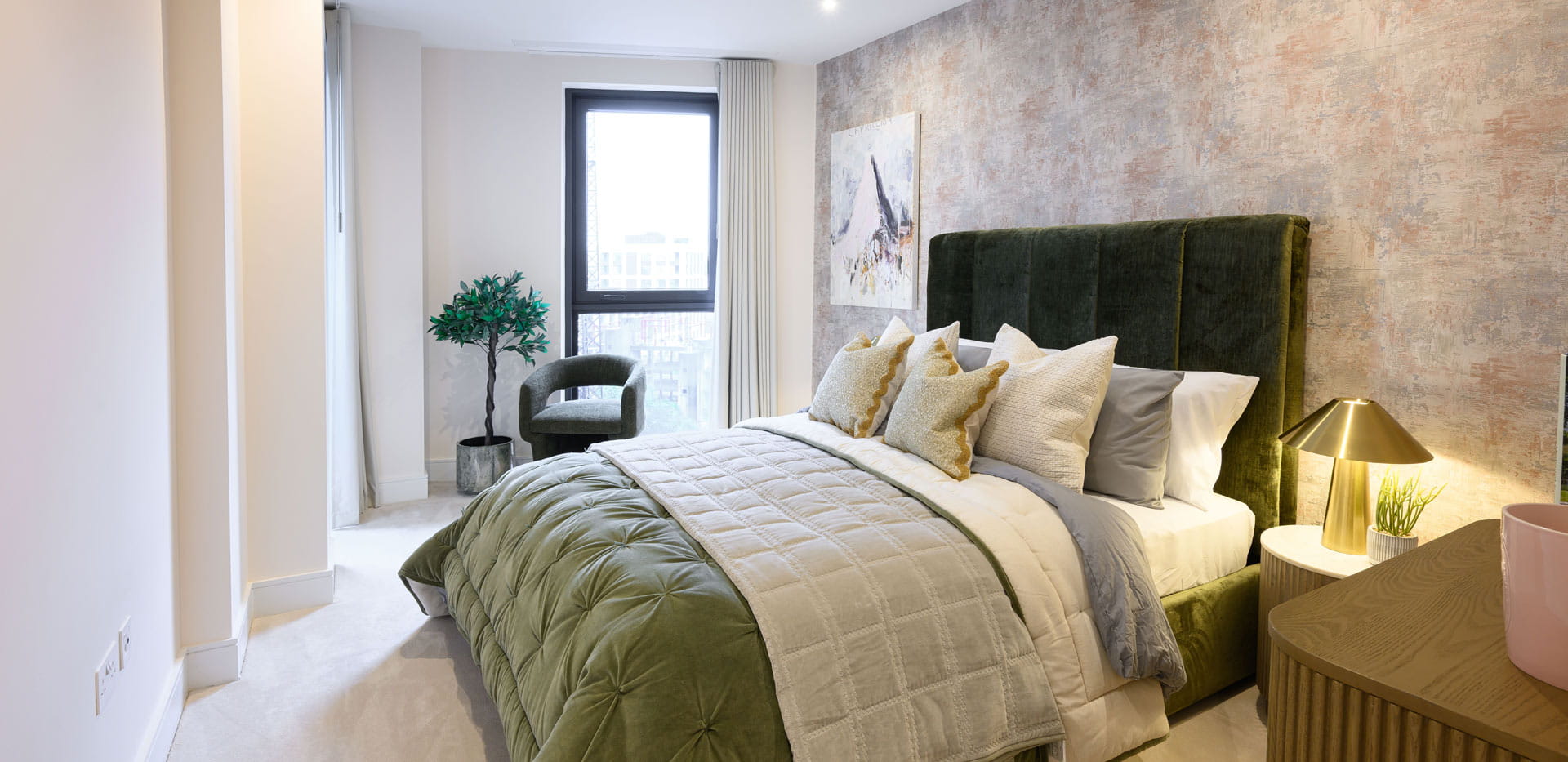Double bed with contemporary design, bedside tables, light tones, carpet flooring.