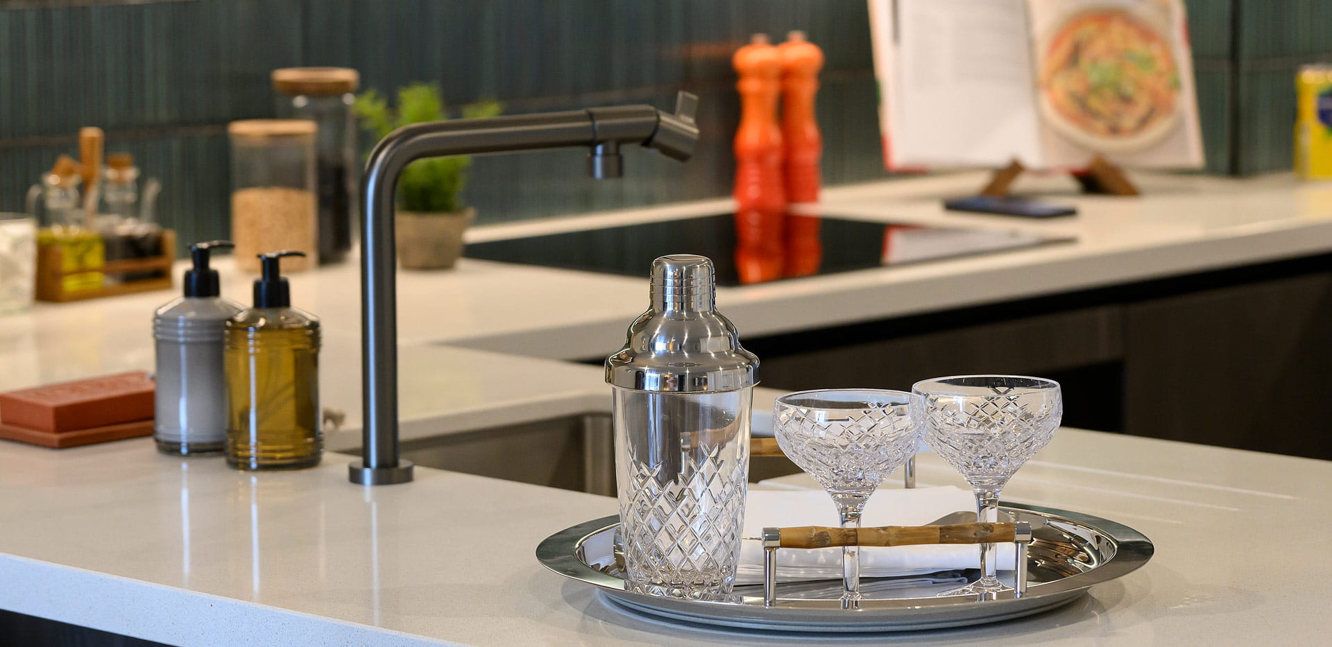 Closeup of kitchen sink with off-white countertops, kitchen decorations.