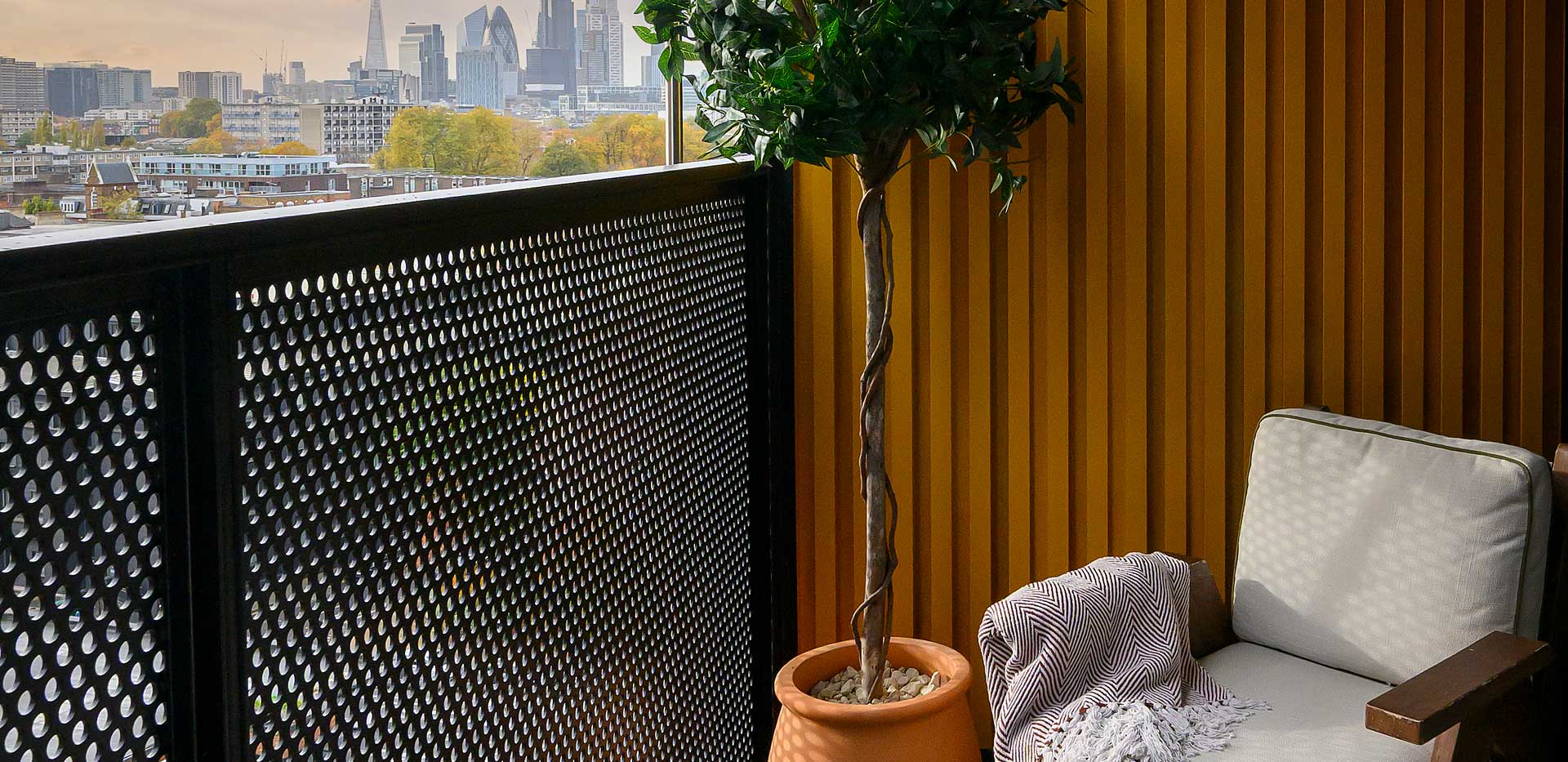 Closeup of balcony view with outdoor furniture, overlooking the city.