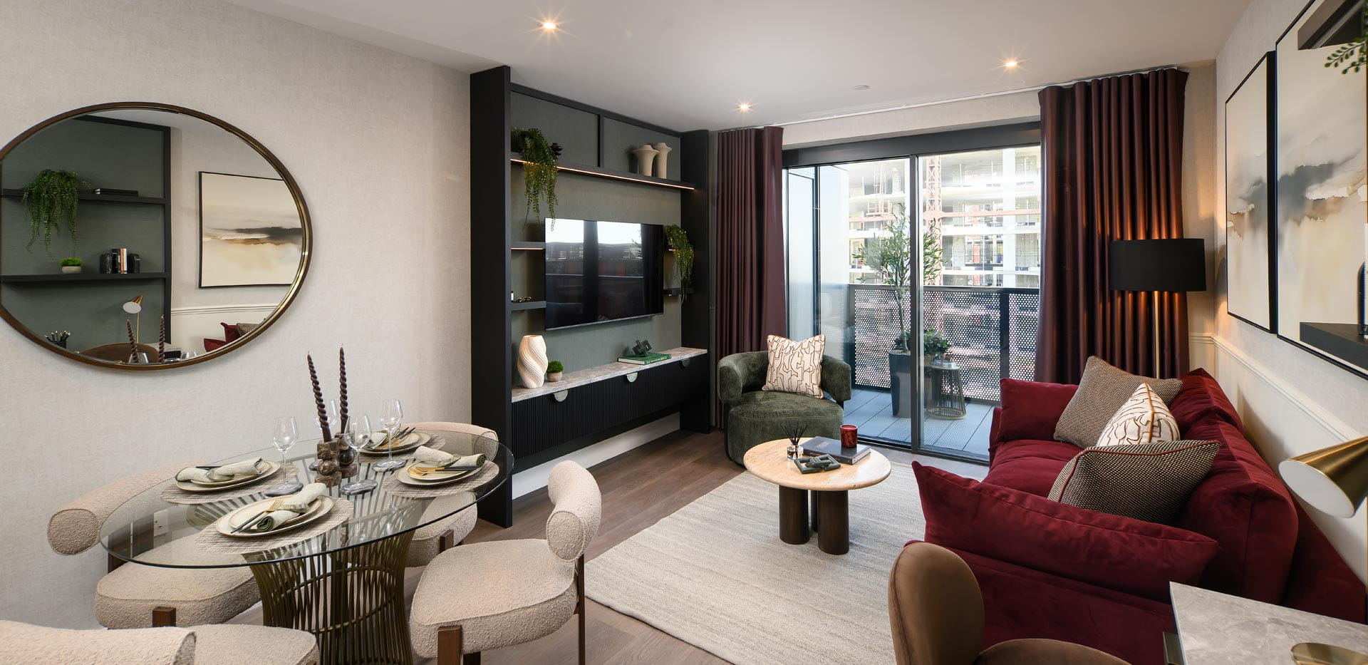 Modern open-plan living room with glass dining table, burgundy sofa and balcony doors.