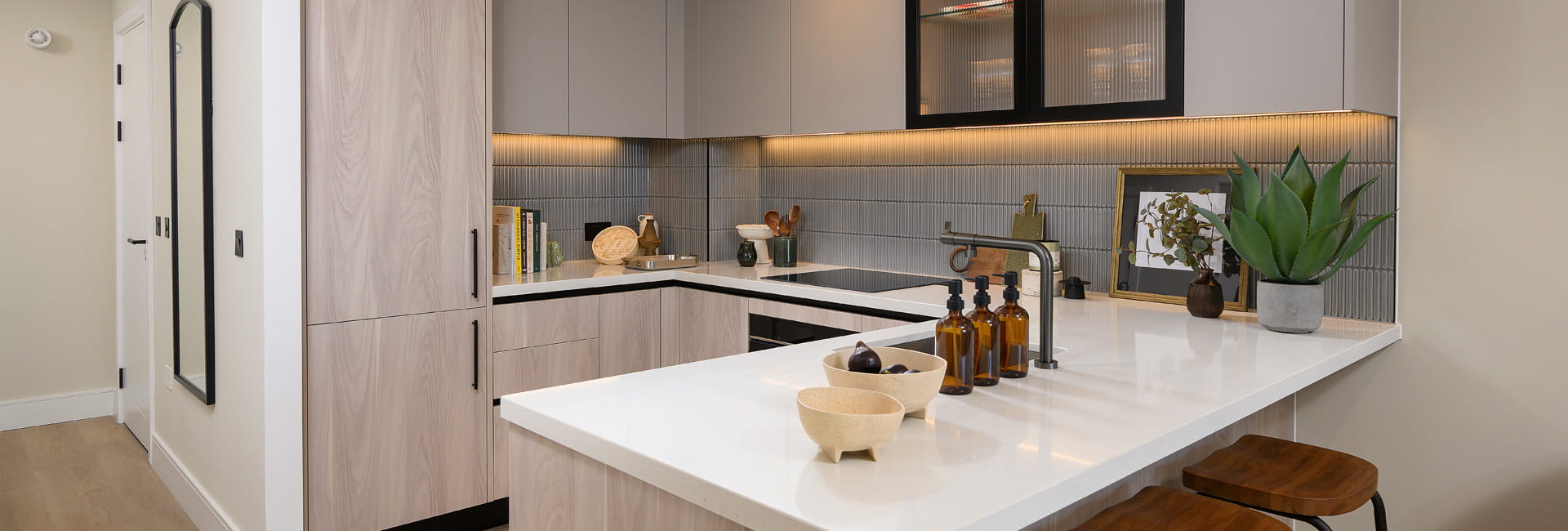 Kitchenette with attached breakfast island, beige surfaces and white countertops