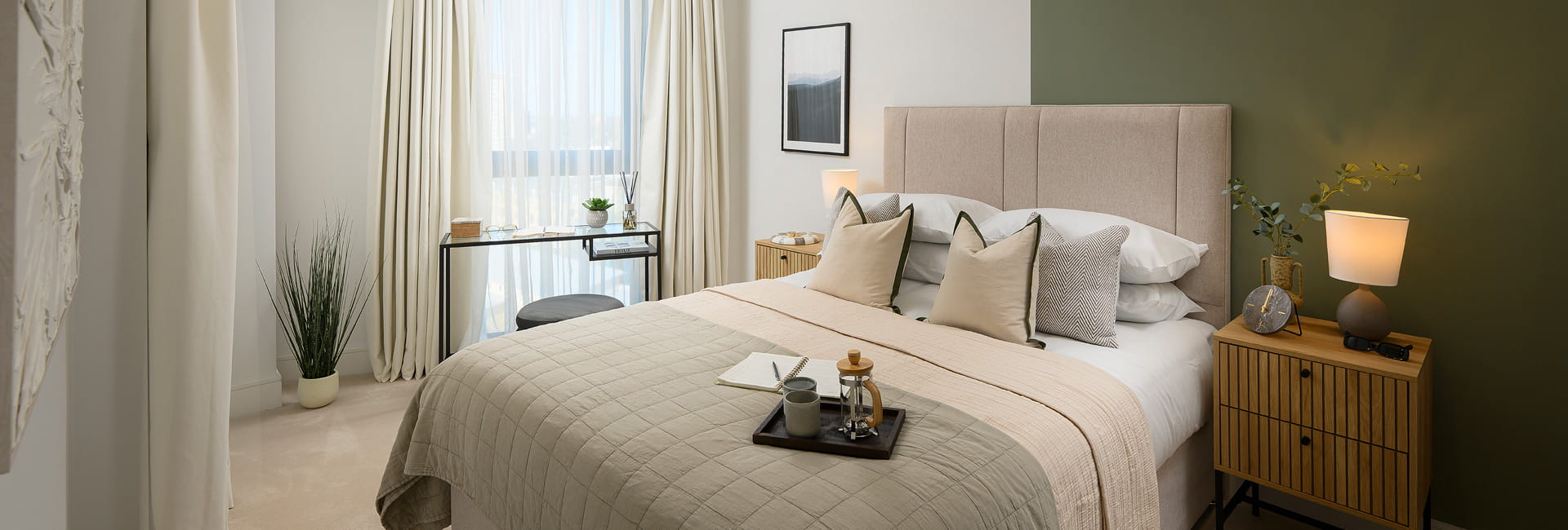 Double bed with wooden bedside tables, green and cream wall colour, off white curtains