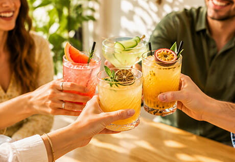 An image of people around a table tapping their drinks together