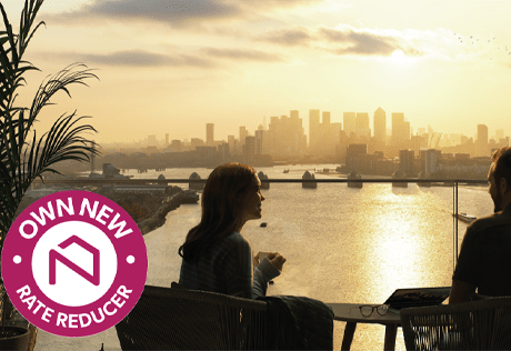 An image of a couple watching the sunset over London on their balcony