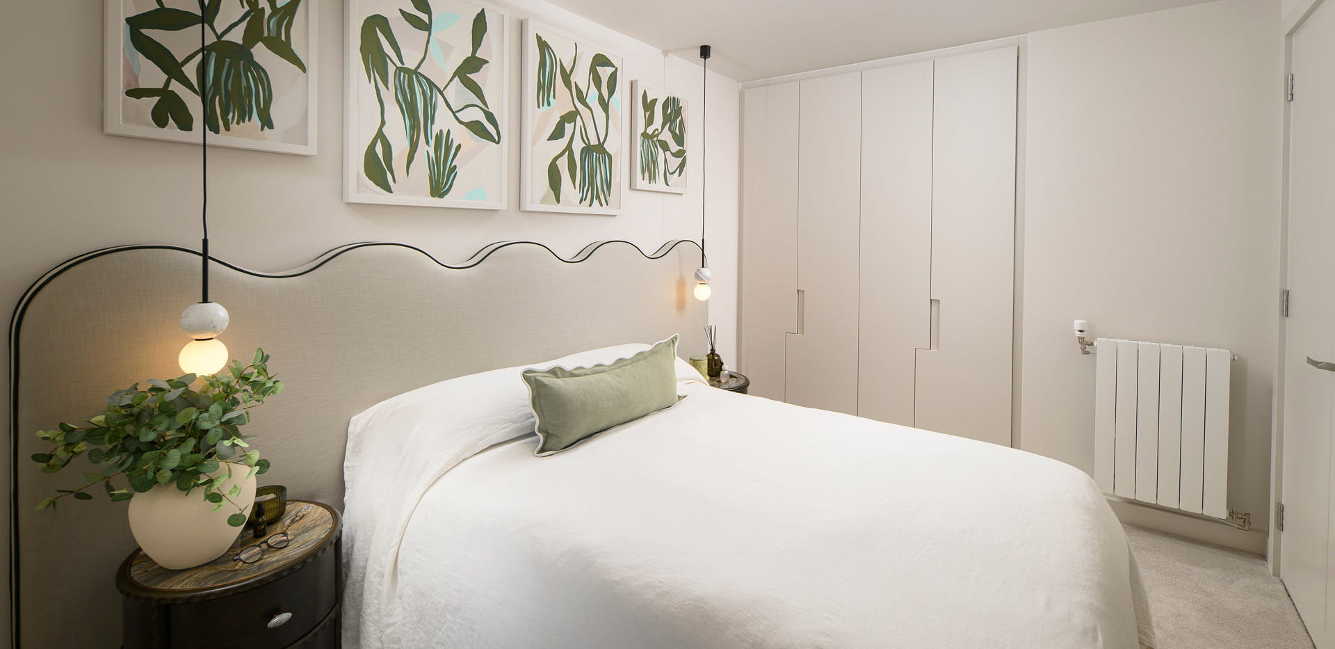 Bed with contemporary design, bedside tables and wall hanging