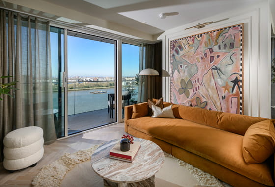 Modern designed living space with chaise lounge and coffee table adjacent to balcony doors