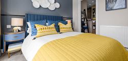 Bedroom with central double bed with blue and yellow bedding
