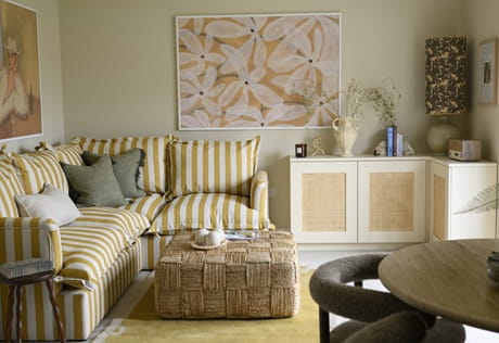 Contemporary designed living space with fabric sofa, coffee table, wall hangings, cabinets and shelving