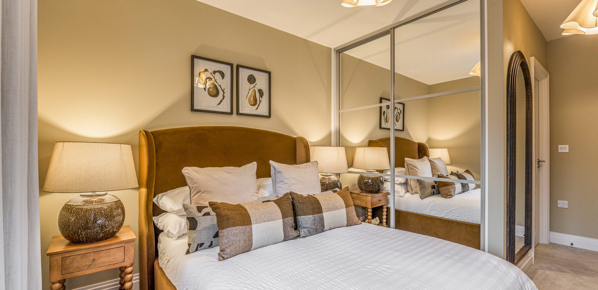 Double bed with bedside tables, and full height mirror built into sliding wardrobe door