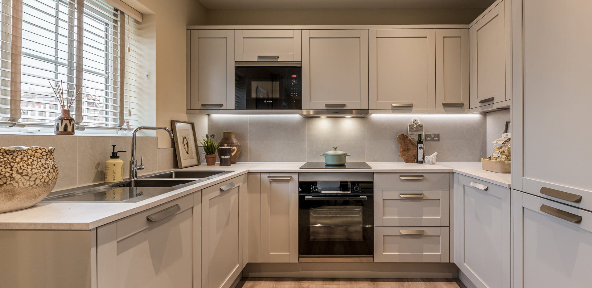Kitchenette with wrap-around white counters, cupboards and drawers