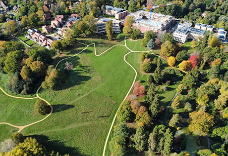Oblique view of a development nestled in acres of greenspace and woodland