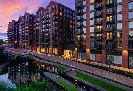 Dawn or dusk setting, view of the development with canal in foreground