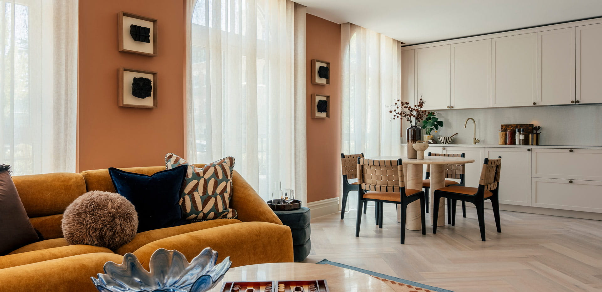 Living space in foreground, kitchen with dining table in background.
