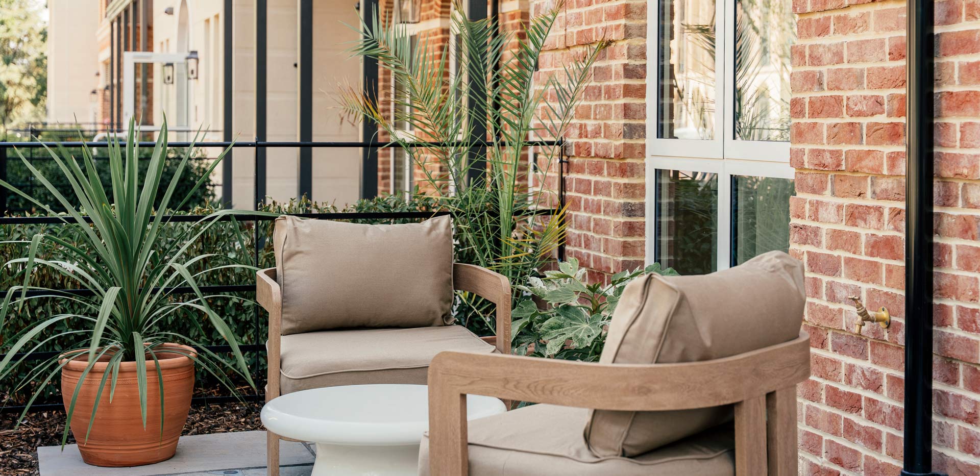 Balcony or terrace view with garden furniture and potted plants on hard standing.