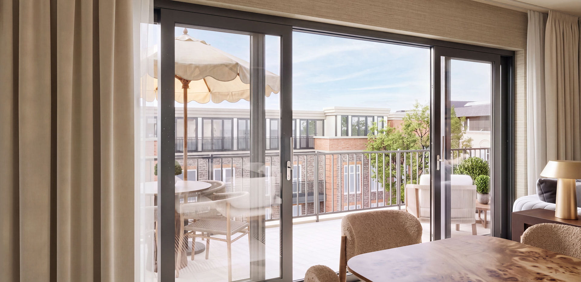 Wooden, polished dining table, with sliding balcony doors and view behind.