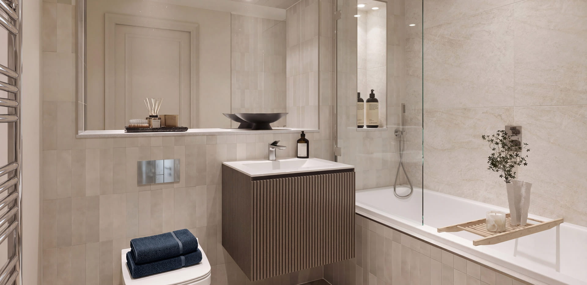 Bathroom with shower over bath, wash basin with wide mirror above, heated towel rack.
