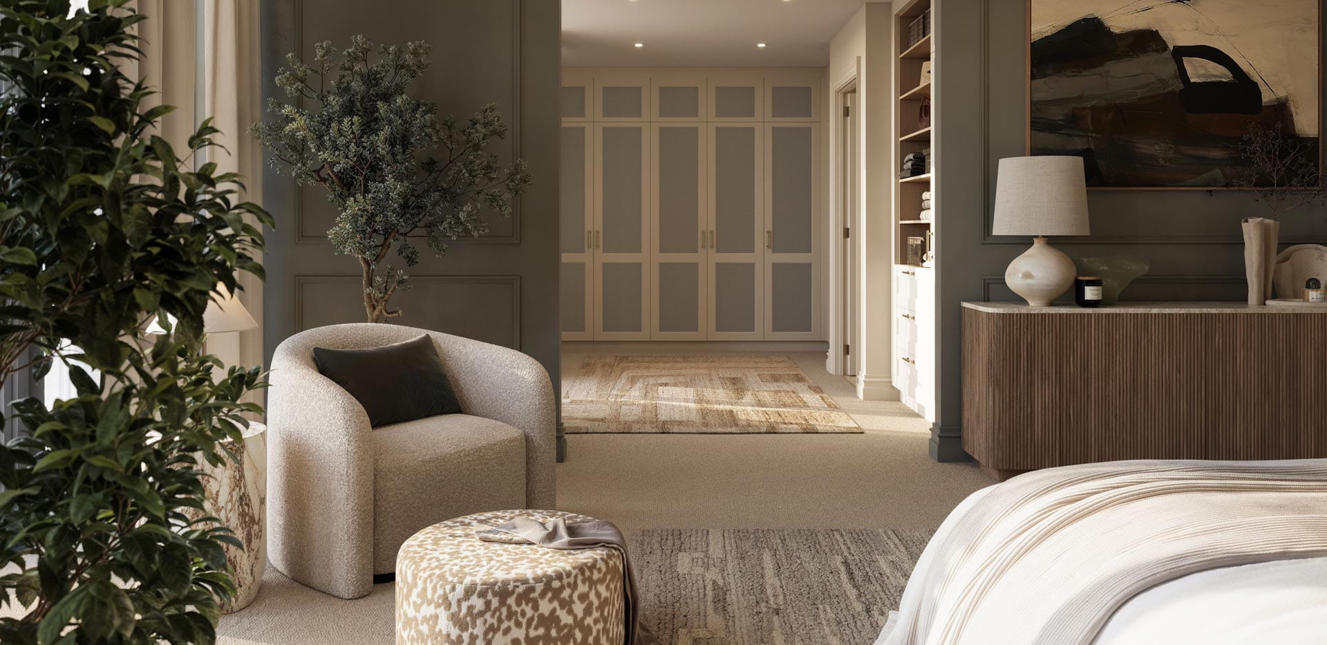 View of side of bed, plant pots, armchair, separate wardrobe room in background