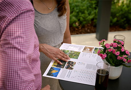 Closeup of two people viewing a brochure pamphlet or leaflet.