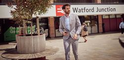 Business man walking out from Watford Junction Station