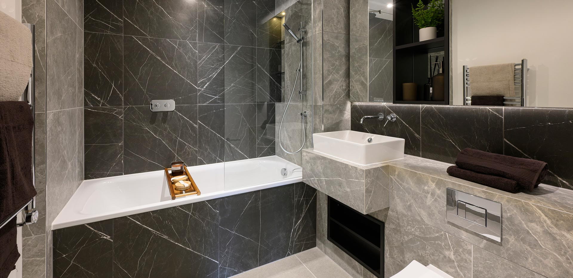 modern designed shower over bath, wash basin with cabinet mirror, heated towel rack and shelving