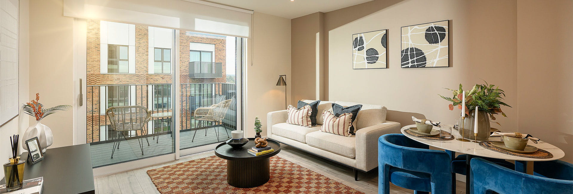 Living space with dining table, lounge chair, 2 seat sofa, coffee table on fabric rug, adjacent to balcony