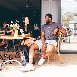 a man and woman having a conversation at a coffee shop at The Green Quarter