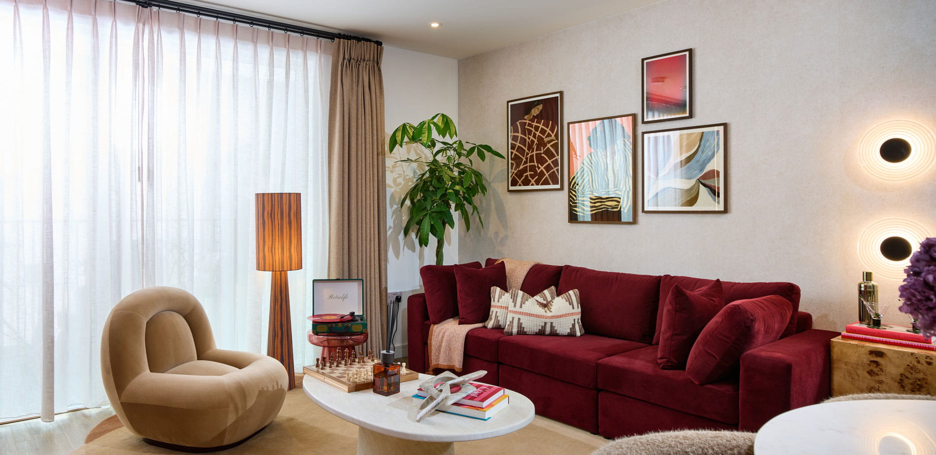 Fabric sofa, coffee table, armchair, wall hangings, high curtains and windows