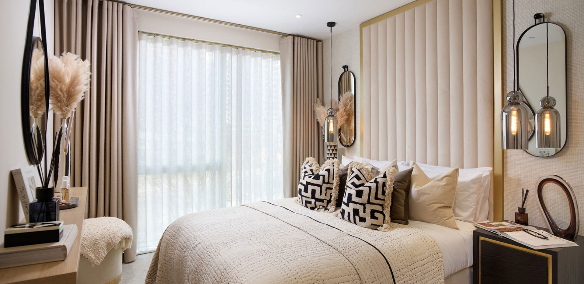 Double bed with contemporary design, bedside tables and wall mirrors.