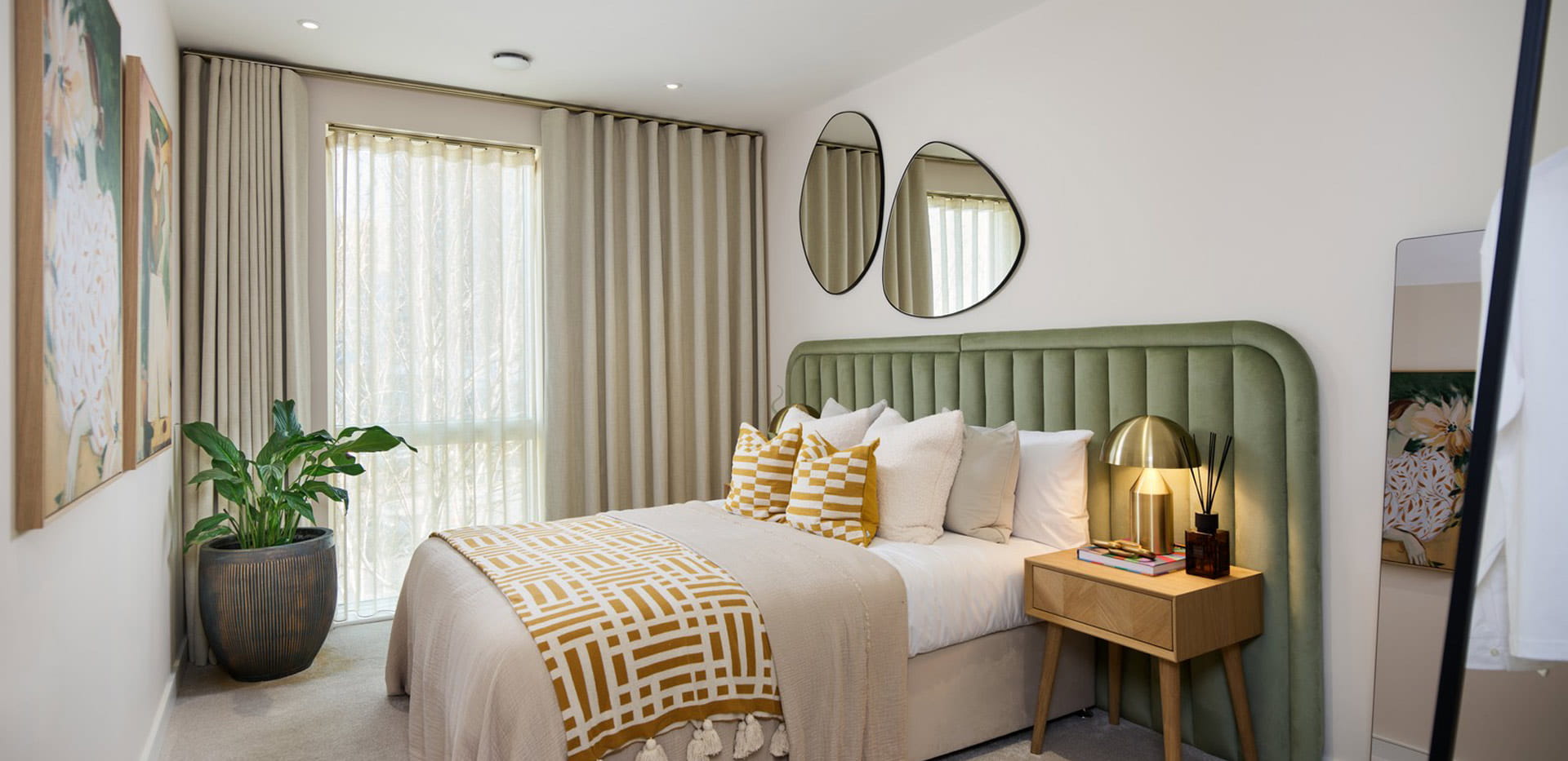 Double bed with contemporary design, bedside tables and wall mirrors.