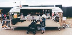 Woman with baby ordering food at the food truck