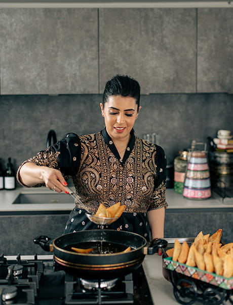 An image of Dipna Anand cooking samosas
