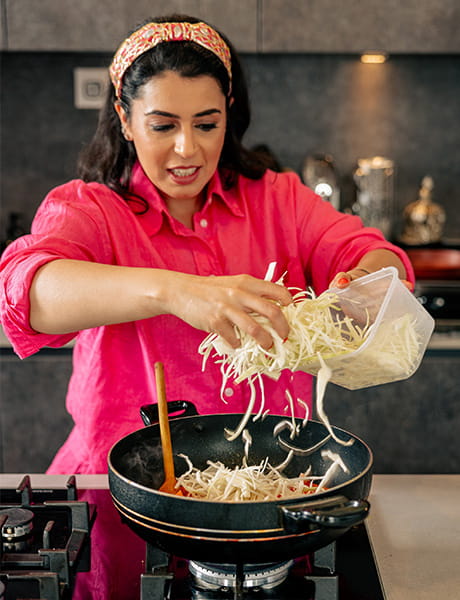 An image of Dipna Anand cooking a meal
