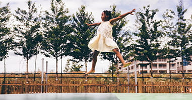 Child jumping on trampoline.