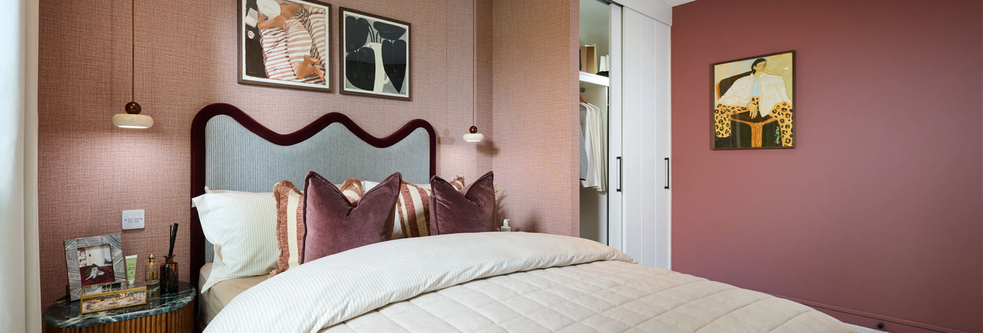 Double bed with contemporary design, bedside tables and wall hanging.