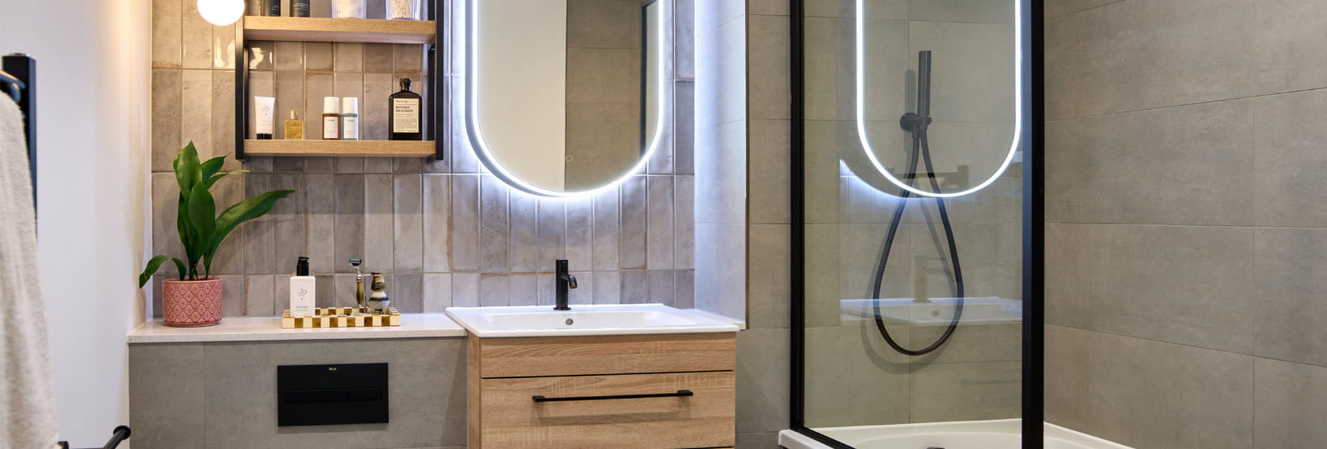 Bathroom with shower over bath, wash basin with halo lighting, towel rack and shelving.