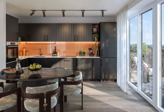 The Orien Foundry Specification: slate-colour kitchenette with orange splash back walls and dining area