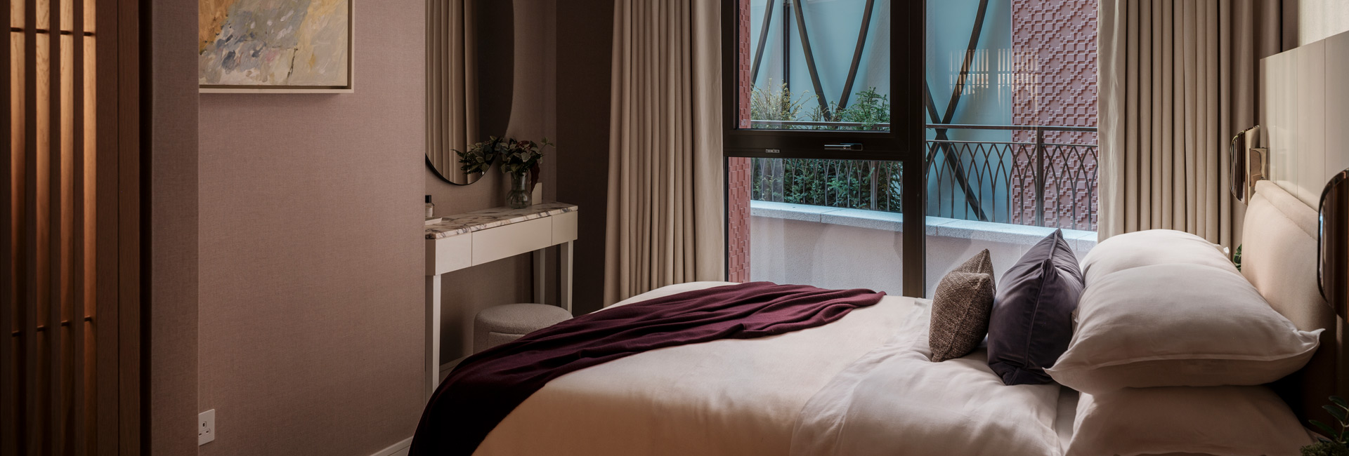 CGI close-up of a made-up bed, wall hanging opposite, vanity table and ample natural lighting from multiple windows.