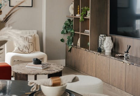 Modern designed living space with TV custom shelving unit, dining table in foreground
