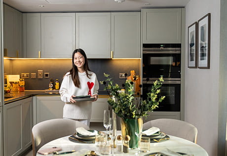 An image of a new resident posing for a photo in her new West End Gate home