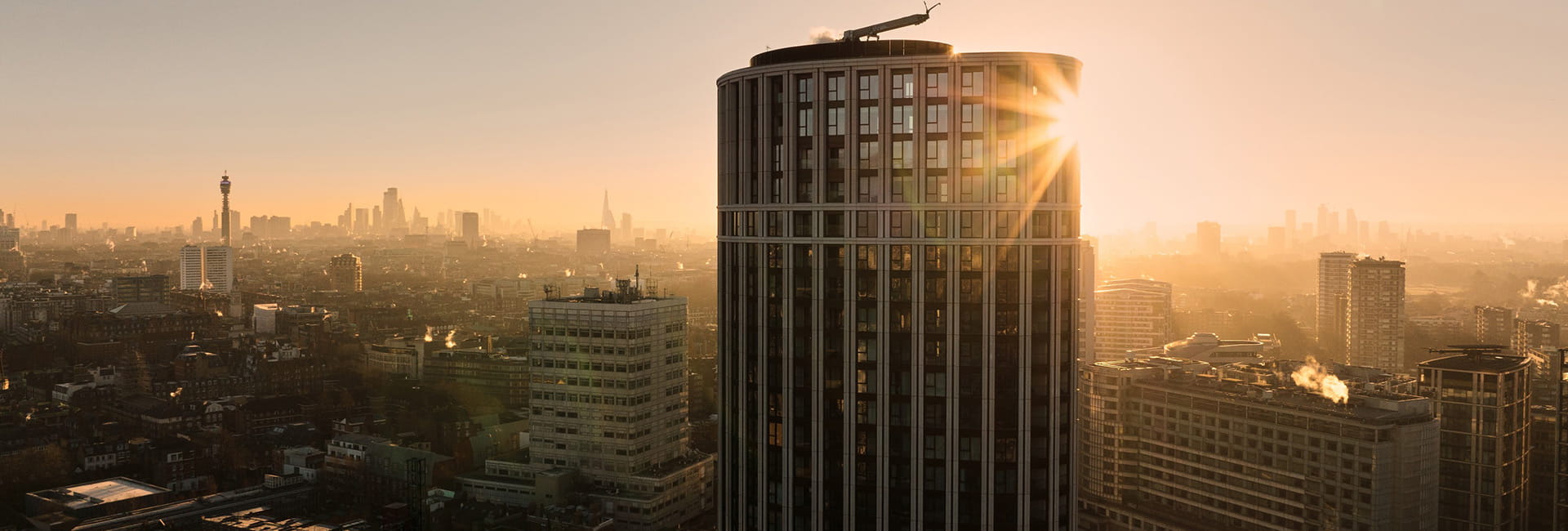 Exterior sunset shot of West End Gate with the sun setting behind the high rise building