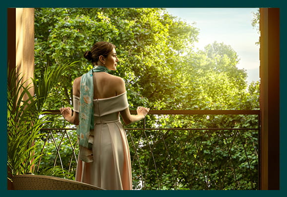 An image of a woman standing on her balcony with the sun shining down on her