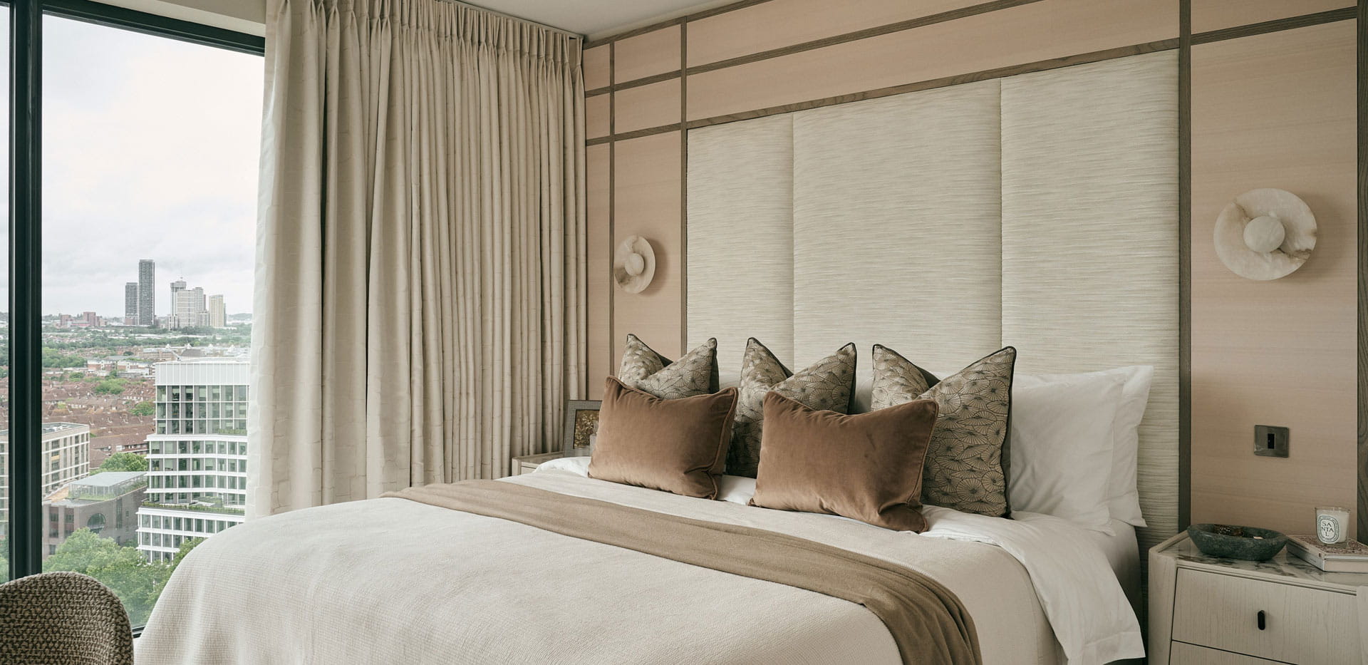 Closeup of double bed, modern design, wide windows with city view.