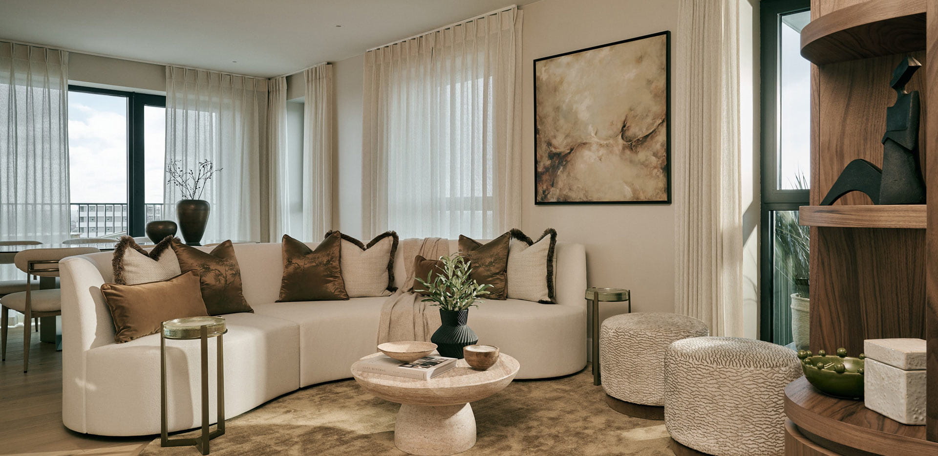 Living space with semi-circular sofa, coffee table, rug, custom shelving unit.