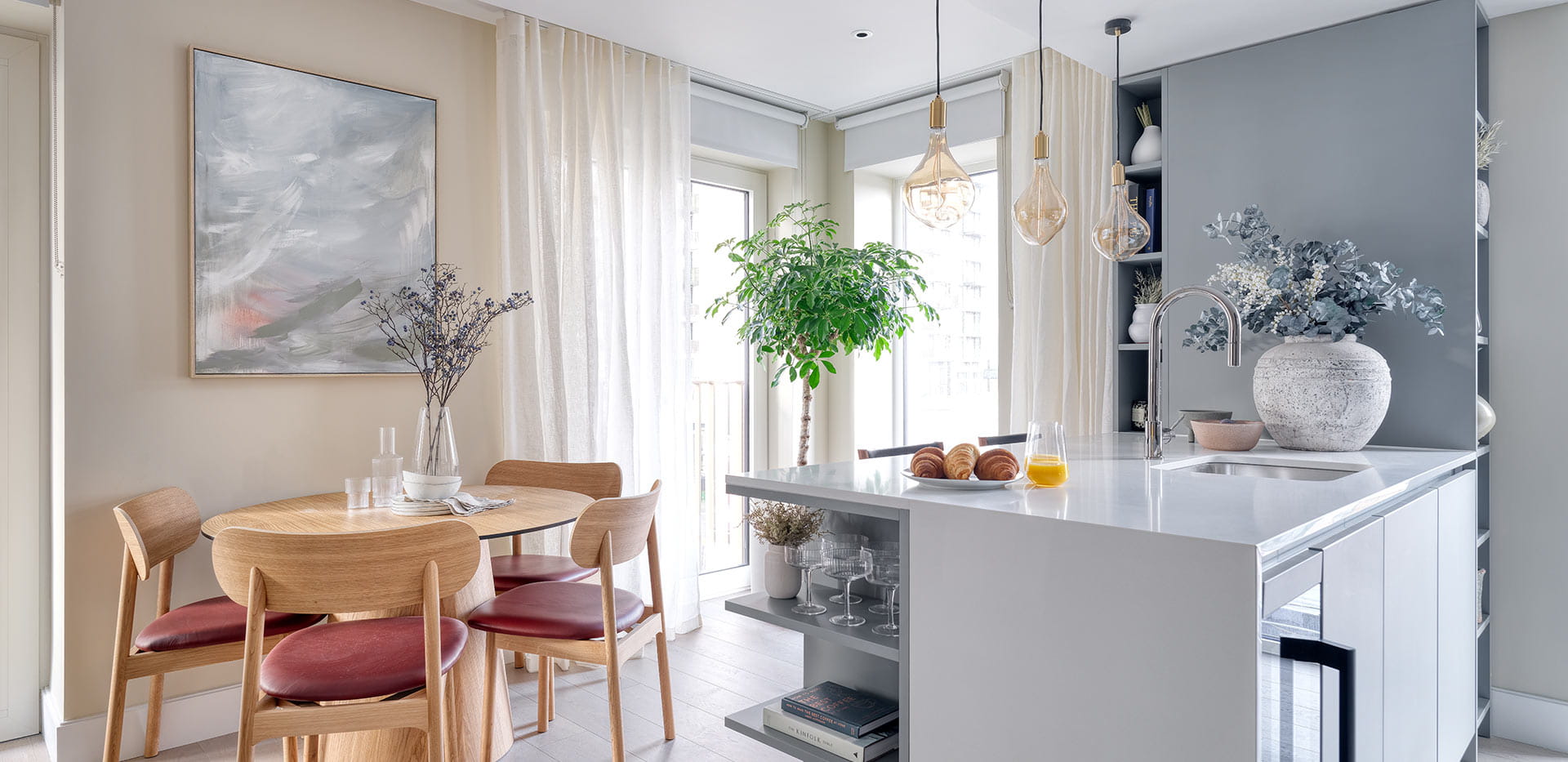 Light themed kitchen and dining area with kitchen countertop and 4 person dining table