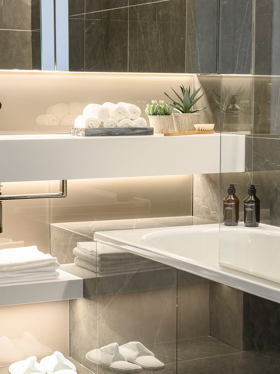 Close of shot of light themed bathroom stocked with soaps and towels